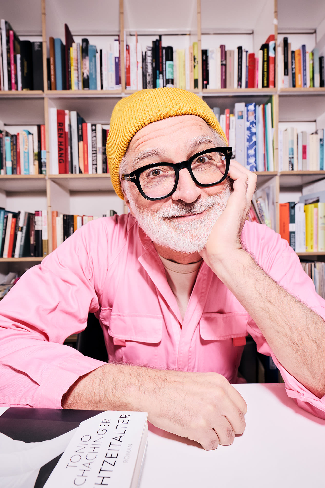 Muž s ružovou košeľou pred policou s knihami - klasické formy investícií do medzigeneračného bohatstva Muž s ružovou košeľou pred policou s knihami - klasické formy investícií do medzigeneračného bohatstva