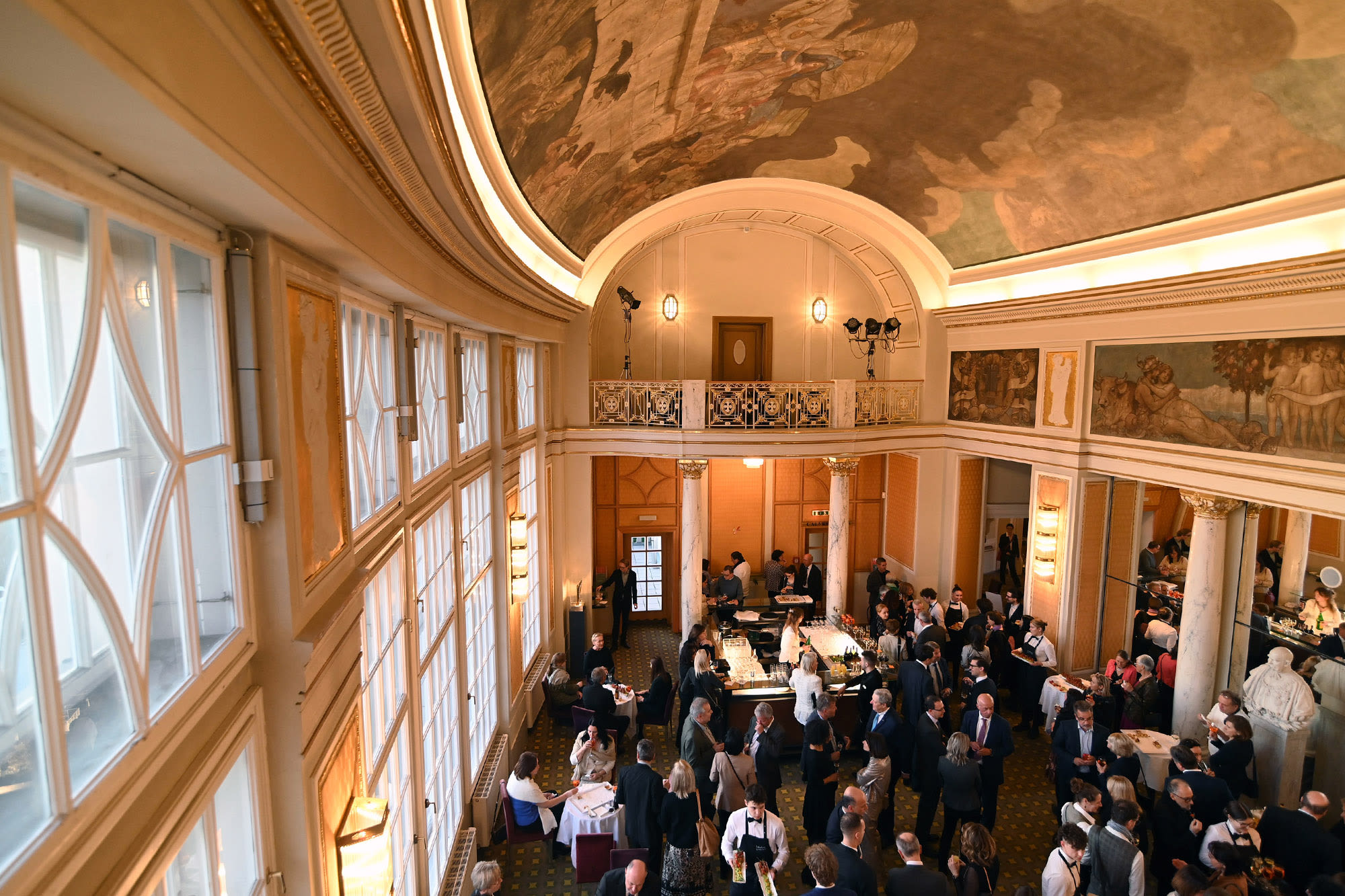 Saal mit vielen Menschen in formeller Kleidung.