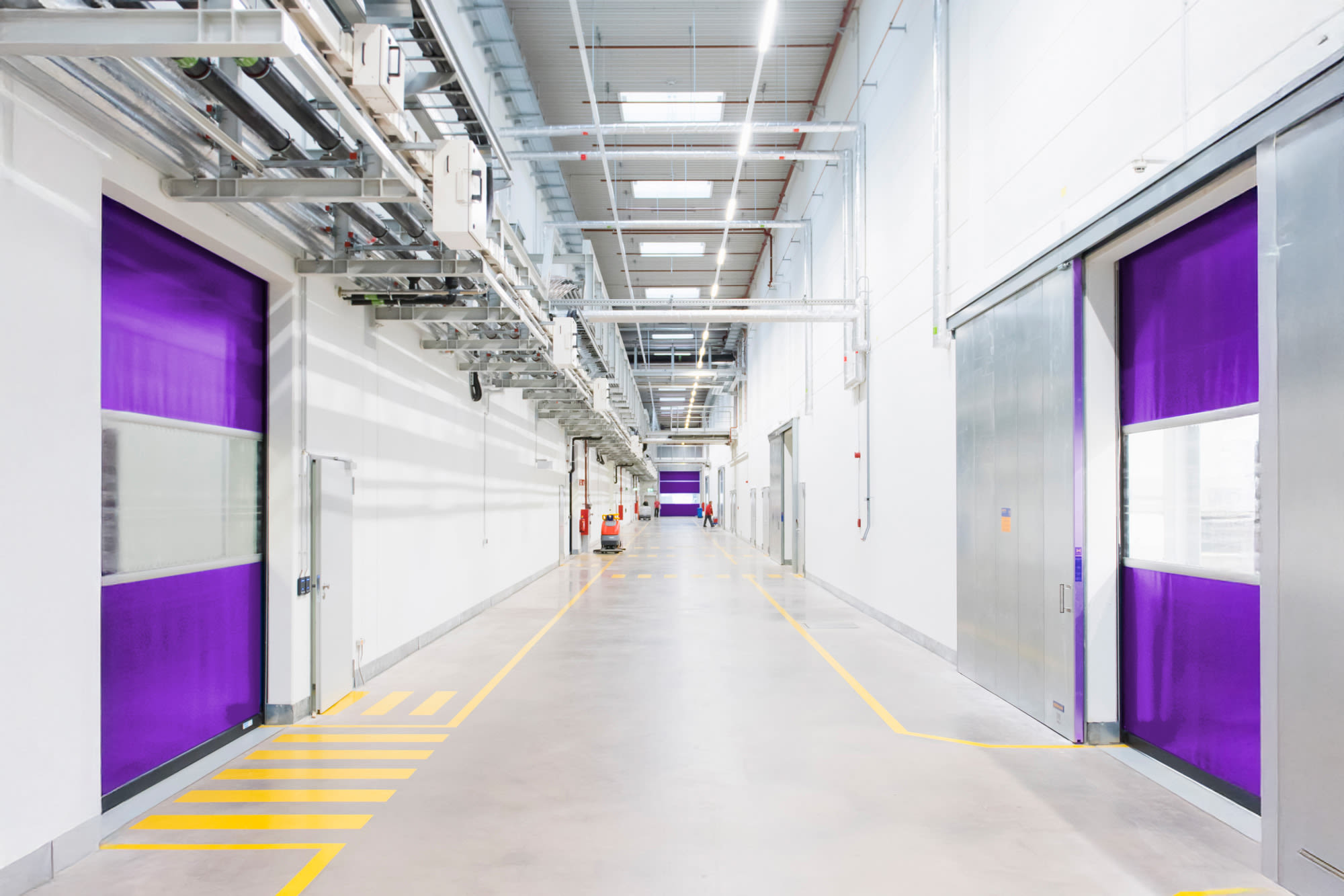 Moderná priemyselná chodba s fialovými dverami - infraštruktúra orientovaná na budúcnosť v BKS.